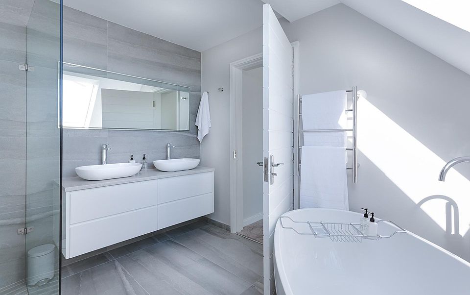 Minimal white bathroom with a floating double vanity, glass shower and freestanding tub