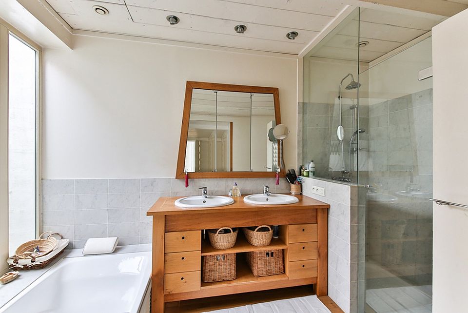 Bathroom with a solid-wood double vanity, framed mirror and glass walk-in shower