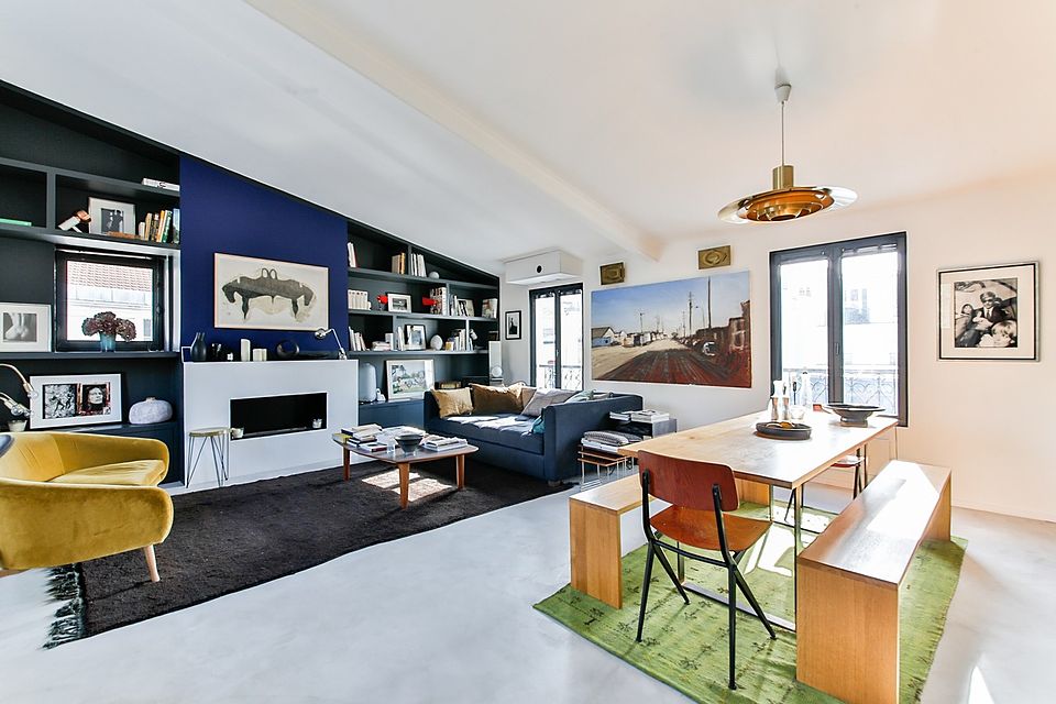 Family room with a navy built-in bookcase wall, fireplace and dining table